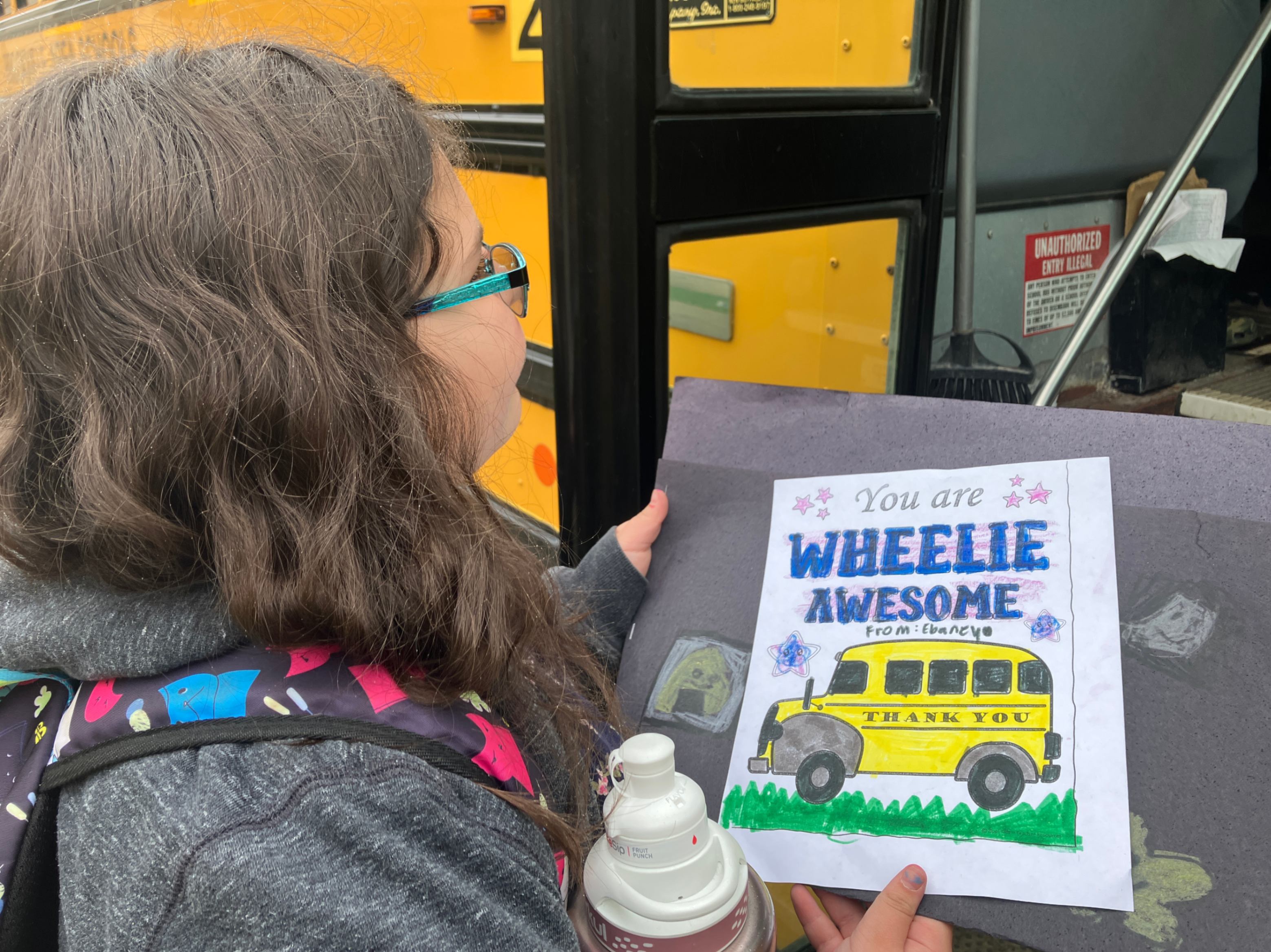Ebaney Irvine is photographed holding her thank you note outside of the bus door.